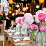Elegant outdoor wedding setup featuring pink floral arrangements and soft lighting.